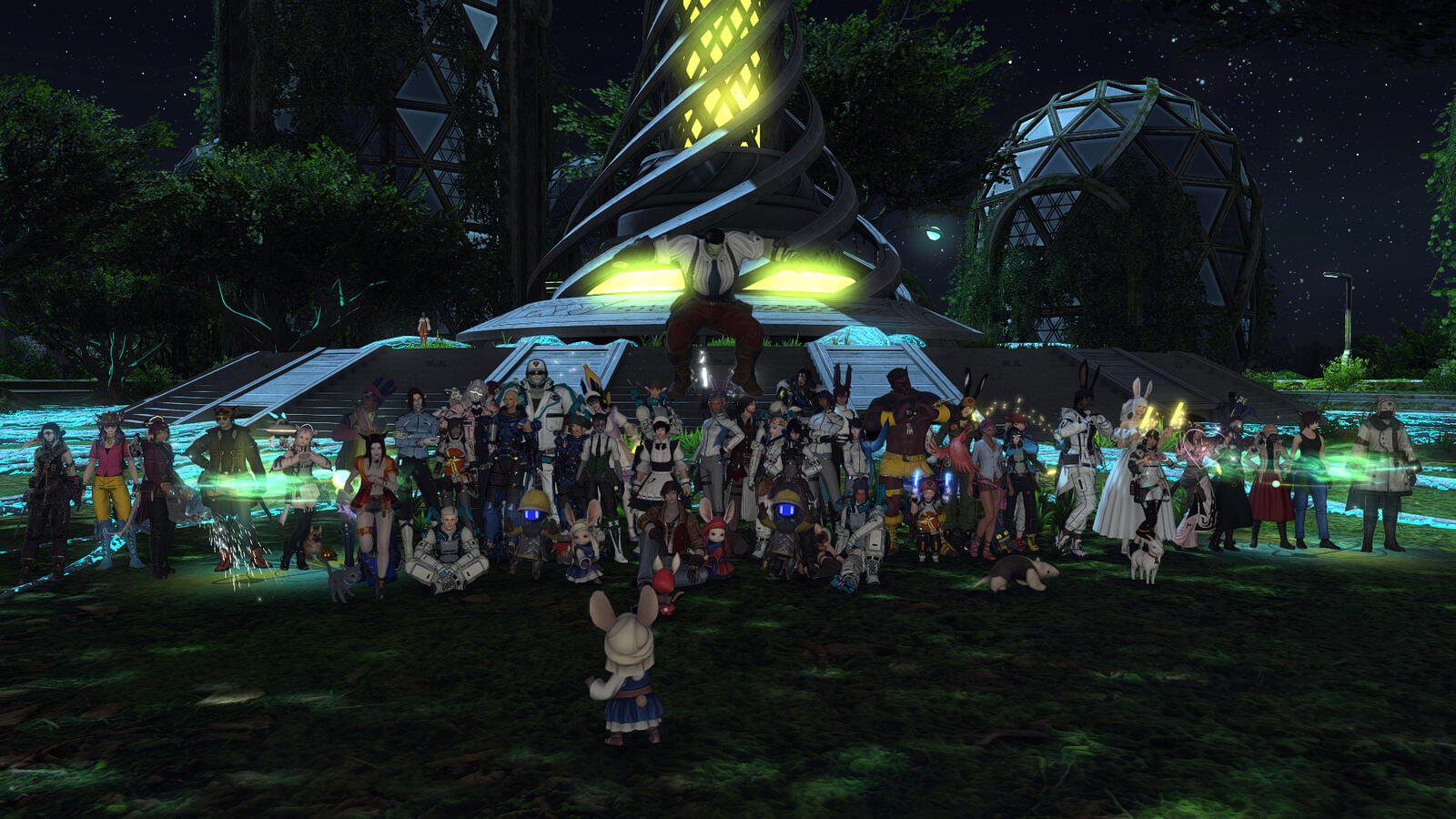 A large group of Warriors of Light gather together for a group photo in front of the newly-awakened Sprouting Towerling on Auxesia, the fourth Cosmic Exploration zone.