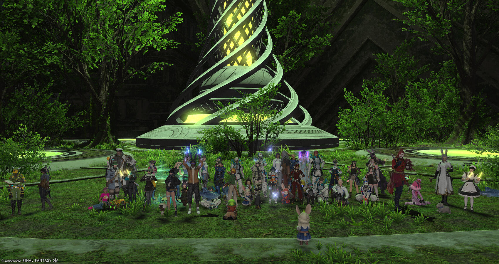 A small group of Warriors of Light on Excalibur gather for a group photo at the vibrantly glowing Rooting Towerling--the one-dull cavern now verdant with green light and life.
